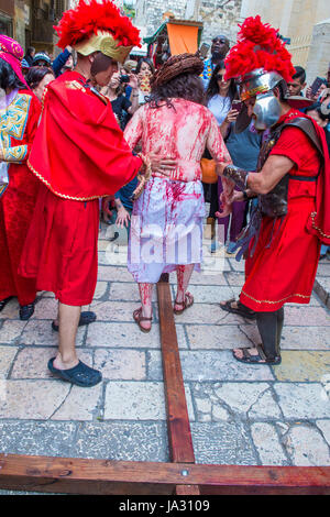 Pellegrino cristiano re-emanare la crocifissione di Gesù lungo la Via Dolorosa in Gerusalemme Israele durante il Venerdì Santo Foto Stock