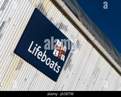 Imbarcazioni di salvataggio RNLI segno sul lato del dipinto di bianco di ferro ondulato scialuppa di salvataggio station building, Eastbourne, East Sussex, England, Regno Unito Foto Stock