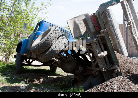 Un carrello con un carico caduto su una dritta Foto Stock