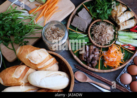 Famoso cibo vietnamita è banh mi thit, popolare cucina di strada dal pane farcito con materie prime: salumi, pate, uovo, lo scalogno, la carota e il cetriolo.. Foto Stock