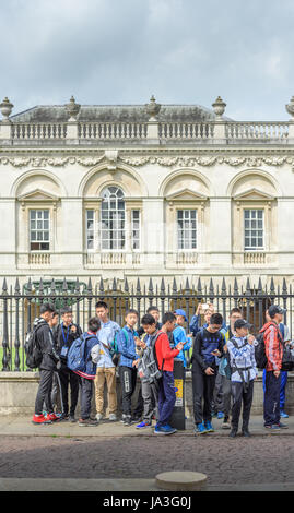 Un gruppo di giovani studenti cinesi di fronte la cancellata al di fuori del Senato dell'università di Cambridge, Inghilterra. Foto Stock