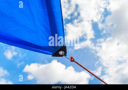 Tende da sole in forma vele su sfondo con cielo nuvoloso. Dettaglio del fissaggio della tenda da sole per il cavo Foto Stock