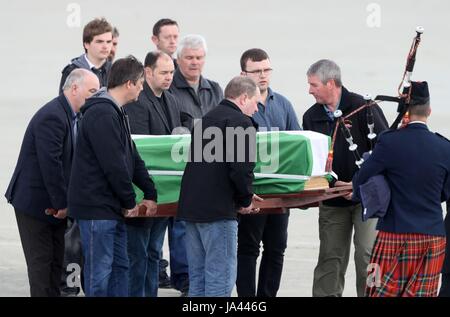 La bara di Eilidh MacLeod drappeggiati nella Barra indicatore è trasportato attraverso Traigh Mhor spiaggia di Barra aeroporto dopo è arrivato dal chartered piano. Il corpo della bomba di Manchester vittima era volato a casa per le comunità devastate sull isola di Barra davanti al suo funerale. Foto Stock