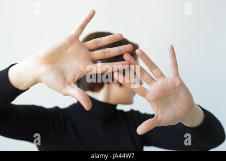 La ragazza si trasforma in disparte, allungando le mani in avanti. Spingere qualcuno lontano dal contatto Foto Stock