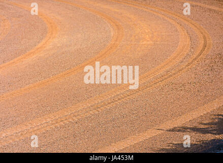 Curva di texture traccia di ruota sul terreno di colore arancione e la strada di sabbia Foto Stock