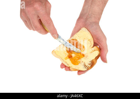 Mani maschio diffusione di marmellata sul pane tostato imburrato isolata contro bianco Foto Stock