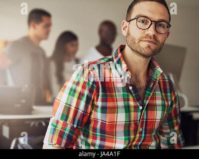 Imprenditore moderno di indossare un abbigliamento informale e bicchieri in ufficio. Foto Stock