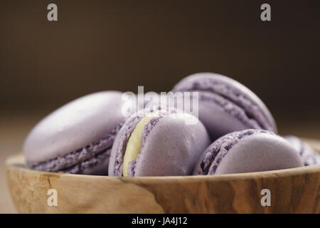 Violetta macarons nella ciotola di legno sul tavolo di legno Foto Stock