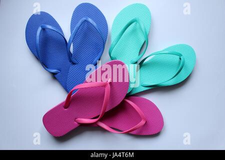 Coppie di scarpe da spiaggia tong a colori su sfondo bianco Foto Stock