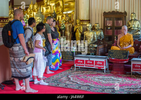 Ai turisti di ammirare una scultura di cera di un monaco di Wat Phra Singh, che è uno dei più famosi templi buddisti in Chiang Mai. Foto Stock