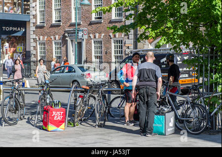 Consegna del cibo per Riders for Deliveroo e mangiano solo prendere una pausa a Cork in Irlanda. Foto Stock