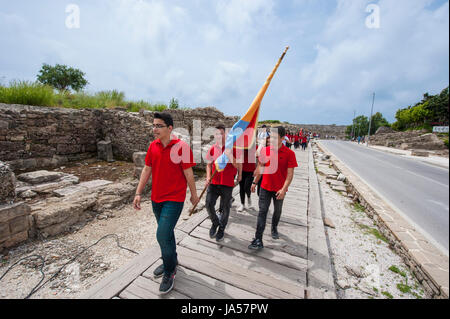 Marciando ai giovani turchi vestito di rosso camicie passando attraverso la zona di antiquariato nel lato, Provincia di Antalya, Turchia. Foto Stock