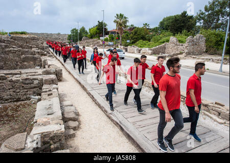 Marciando ai giovani turchi vestito di rosso camicie passando attraverso la zona di antiquariato nel lato, Provincia di Antalya, Turchia. Foto Stock