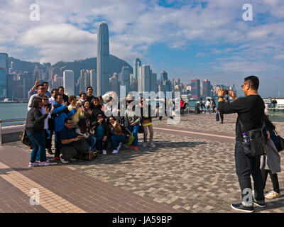 Vista orizzontale di turisti di scattare le foto del drammatico skyline di Hong Kong Island, Cina. Foto Stock