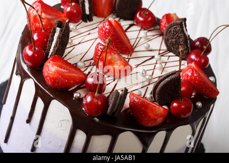 Mousse con fragole e ciliege, decorato con biscotti e cioccolata di close-up. Posizione orizzontale Foto Stock
