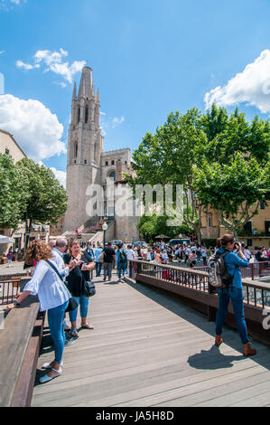 La gente che camminava su un ponte sul fiume Onyar, durante l'annuale festival dei fiori "temps de flors 2017". Sullo sfondo è possibile vedere la Cattedrale Foto Stock