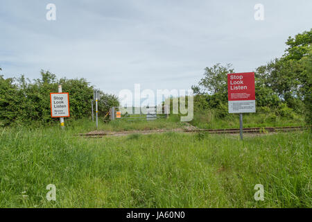 Due pedoni cartelli di avvertimento in corrispondenza di un incrocio ferroviario nella campagna che dice 'Stop, guarda, ascolta" Foto Stock