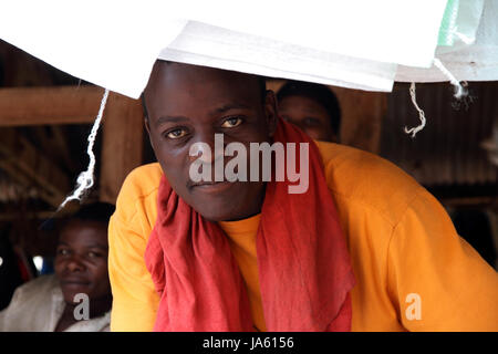 KAMPALA, UGANDA - Settembre 28, 2012. Un attraente giovani ugandesi fornitore del mercato guarda nella telecamera lungo il lato del suo compagno di fornitori sul mercato a Kampala in Uganda nel settembre 28,2012. Foto Stock