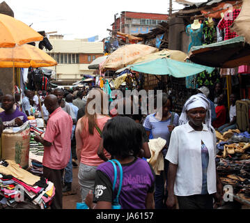 KAMPALA, UGANDA - Settembre 28, 2012. Una donna bianca si allontana attraverso un mercato shopping tra la gente del posto a Kampala in Uganda nel settembre 28,2012. Foto Stock