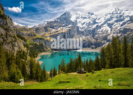 Incredibile tourquise Oeschinnensee con cascate, chalet in legno e Alpi Svizzere, Berner Oberland, Svizzera. Foto Stock
