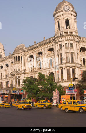 Giallo taxi attraversare una strada trafficata giunzione in Kolkata, West Bengal, India. Foto Stock