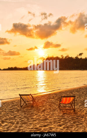 Sedie da spiaggia in sabbia affacciato sul mare al tramonto. Della Thailandia Foto Stock