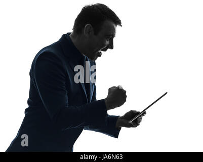 Un caucasian business man holding digitale compressa felice successo in silhouette su sfondo bianco Foto Stock