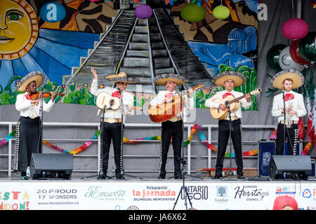 Tradizionale mariachi band che suona musica dal vivo sul palco della Fiesta Londra! Festival messicano, mariachi gruppo, musicisti mariachi, tradizionale musica messicana, gruppo di cinque musicisti messicani che indossa il Messico sombreros e suonare strumenti mariachi. Foto Stock