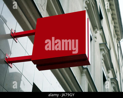 Cartello vista laterale del rosso vuoto mock up digital signage con un moderno city Wall display di sfondo esterno. Foto Stock