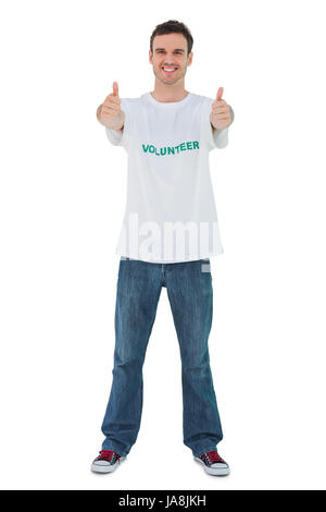 Attraente uomo che indossa volontario tshirt dando pollice in alto su sfondo bianco Foto Stock