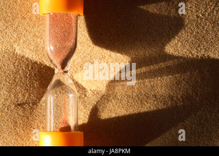 Concetto di tempo. Primo piano della clessidra su abstract Sfondo sabbia con spazio libero per il testo Foto Stock