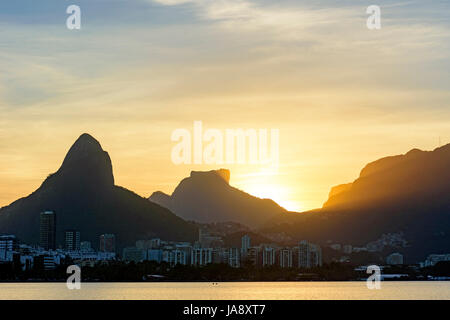 Immagine del tardo pomeriggio alla laguna di Rodrigo de Freitas a Rio de Janeiro con le sue montagne, gli edifici e il profilo caratteristico Foto Stock