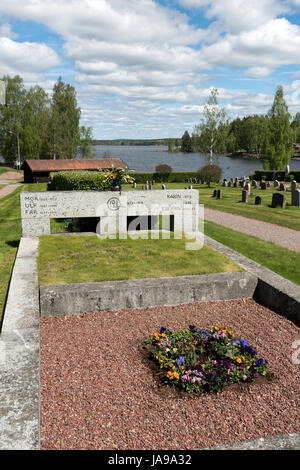 Cimitero sul lago in Svezia con lapidi e fiori in una giornata di sole circondato da alberi e acqua. Foto Stock
