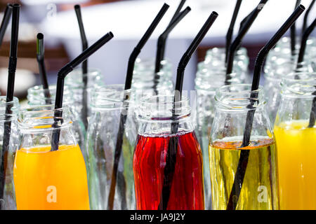 Cocktail colorati o succhi di frutta, scatti con cannucce in piccoli flaconi di vetro. Foto Stock