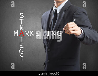 Business man iscritto la strategia di marketing concept by crossword Foto Stock