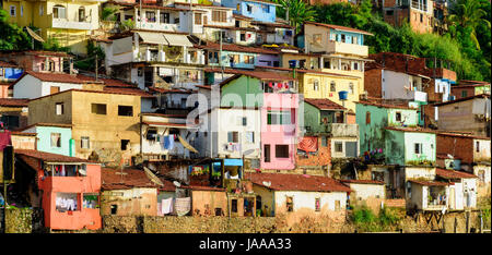 Baraccopoli di contorno con le sue case colorate sulla collina al mare nella città di Salvador di Bahia, Brasile Foto Stock