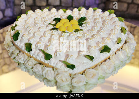 Bel cuore di nozze a forma di torta al limone decorata con rose Foto Stock