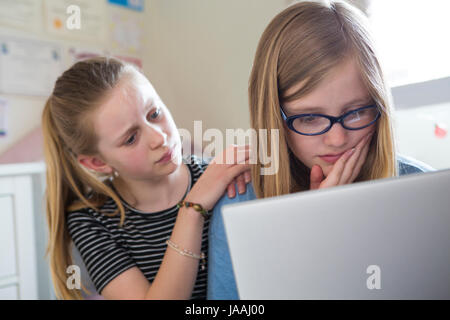 Pre-Teen Ragazza con amico di essere vittima di bullismo On Line Foto Stock