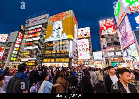 Ebisu bridge in Dotonbori, Osaka. La folla di turisti che si godono il neon cartelloni illuminata di sera, Kanidoraku ristorante con birra può firmare Foto Stock