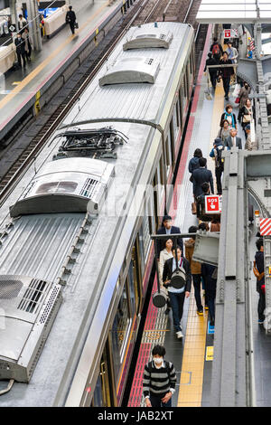 Osaka stazione ferroviaria. Vista aerea della piattaforma con il treno dei pendolari arrestato. Alcune persone sulla piattaforma. Foto Stock