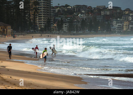 Surfisti a Manly Beach in un giorno di tempesta. Periferia nord di Sydney, NSW, Australia. Foto Stock