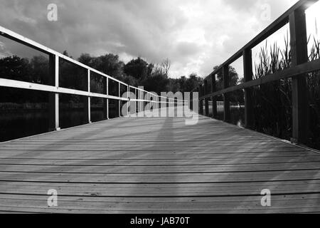 Un ponte di legno su un lago Foto Stock