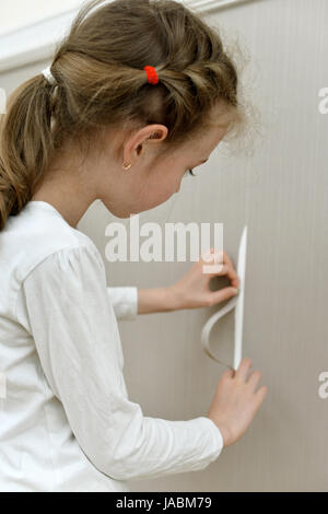 Bambina accidentalmente rovinato la carta da parati. Foto Stock