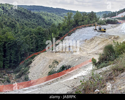 Cantiere in colline con escavator di scavo Foto Stock