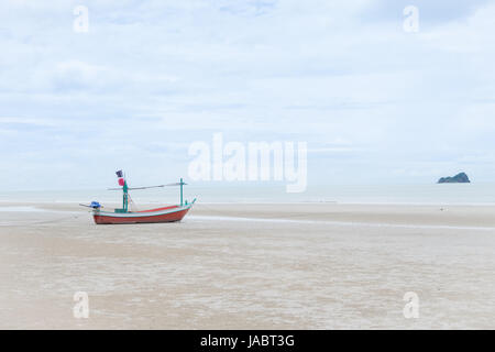 Longtail boat sulla spiaggia e cielo blu nel giorno nuvoloso Foto Stock