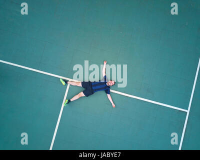 Sport uomo giaceva sul campo dopo il gioco dell'antenna vista superiore Foto Stock