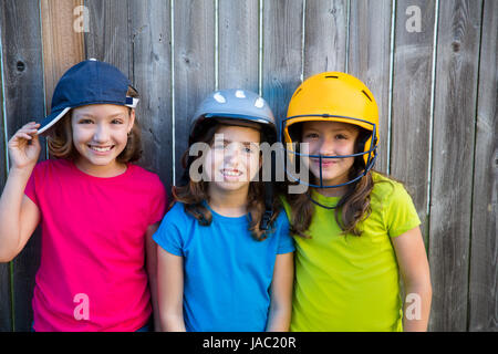Sorella e amici sport kid ragazze ritratto sorride felice su grigio recinzione cortile di legno Foto Stock
