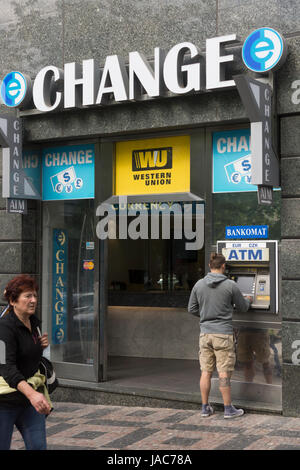 Una persona ritirare contanti da un ATM in un Western Union bureau de change / cambio valuta a Praga, Repubblica Ceca Foto Stock
