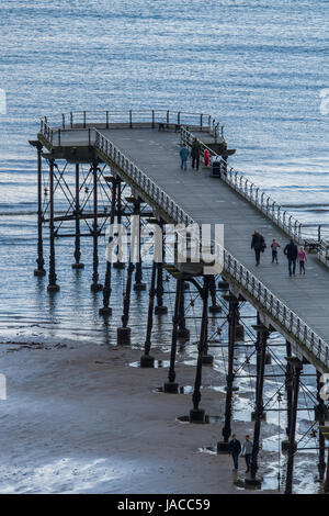 Vista dall'alto di persone sul piacere vittoriano pier, proteso nel Mare del Nord su grigio giornata di primavera - Cambs, North Yorkshire, Inghilterra, GB, UK. Foto Stock