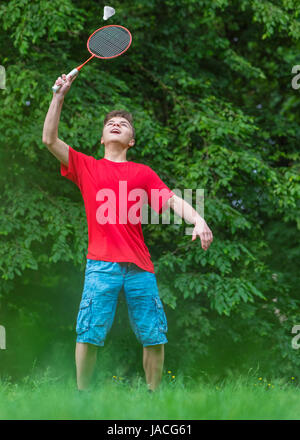 Teen boy playing badminton in posizione di parcheggio Foto Stock